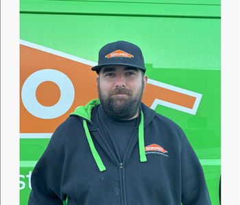 Male employee against a green and orange background 