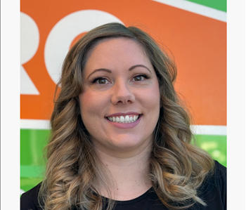 Woman employee against a orange and green background 