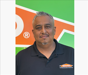 Man in front of green and orange background