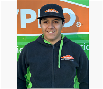 Man in front of green and orange background