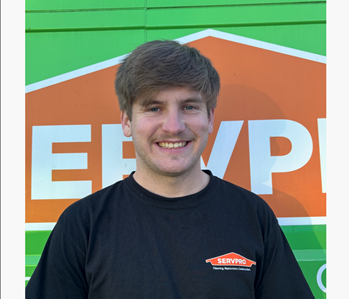 Male employee against a green and orange background 