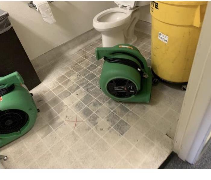 Fan drying water damage in bathroom